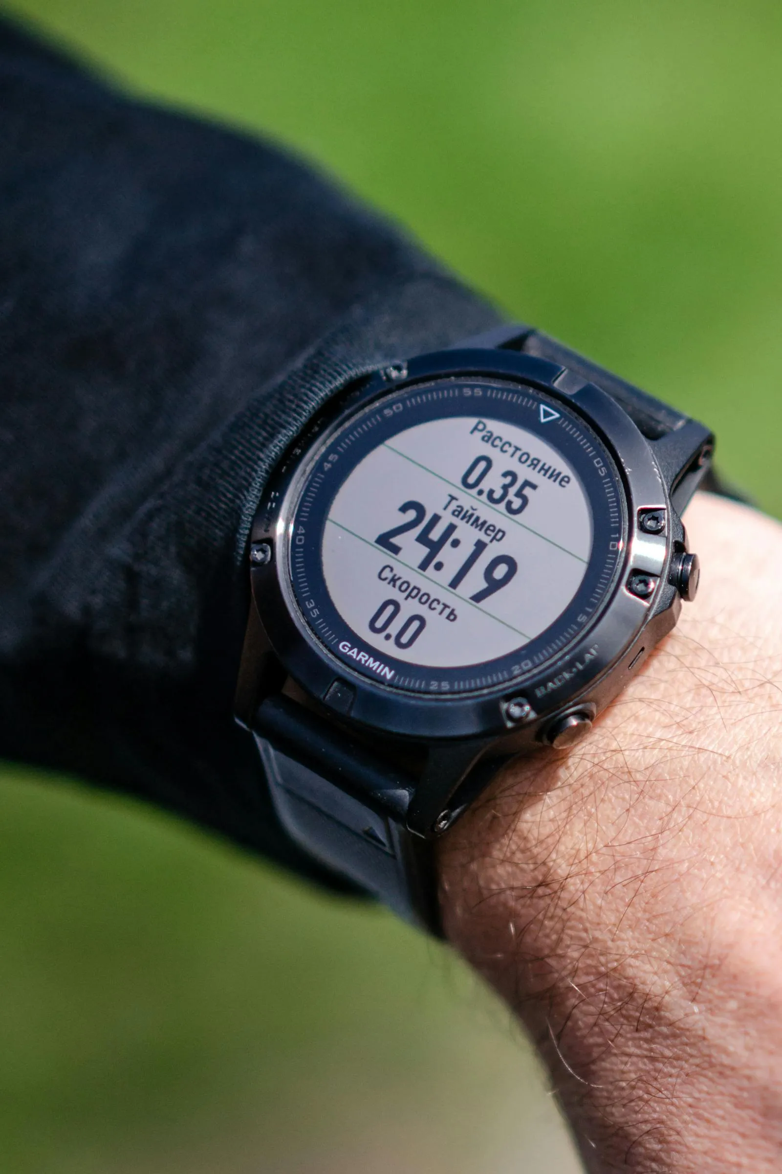 A sports watch on a wrist displays live fitness metrics — heart rate, pace, calorie burn